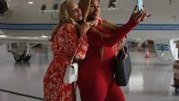 Hunting Housewives: Two women take selfies by a plane
