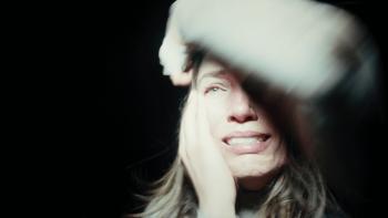 Hunting Matthew Nichols Movie: In the dark, Tara appears terrified, an arm over her forehead, a light shining in her face
