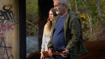 Hunting Season Movie: Tag (Sofia Hublitz) and Bowdrie (Mel Gibson), who holds a rifle, look at something
