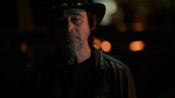 Hunting Season Movie: In black leather and a black hat, villain Alejandro (Jordi Mollà) looks at something with distaste