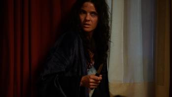 Hunting Season Movie: Wounded and scared, January (Shelley Hennig) crouches near a wall while holding a small knife