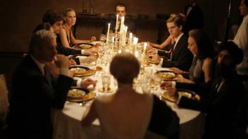 I Am Love: A coupe of people sit at a formal dining table lit by candlelight