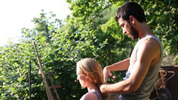 I Am Love: Tilda Swinton sits in a garden in front of Edoardo Gabbriellini, who cuts her hair from behind