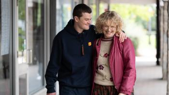 I Swear: Robert Aramayo puts his arm around Maxine Peake as they walk along a high street