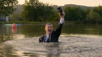 I Can't Live Without You: Man in body of water with phone in hand