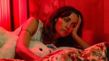 If I Had Legs I'd Kick You movie: Linda (Rose Byrne) lies next to a sick child in bed, a stuffed animal in her arm