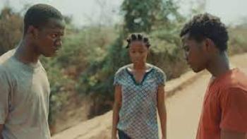 Ijogbon scene 1: 2 Black young men and a Black young woman look tense in the road