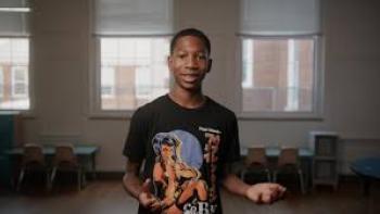 Immutable movie: Black male student smiles and holds hands out