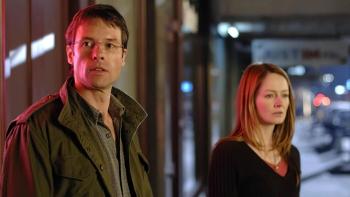 In Her Skin: A White married couple look concerned as they stand in a street