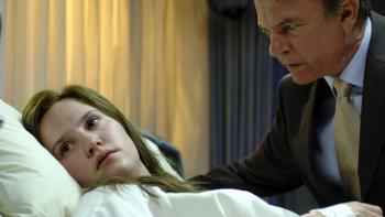 In Her Skin: A young White woman lays in a hospital bed as an older White man looks over her