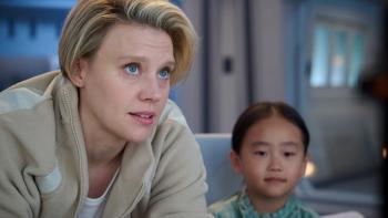 In the Blink of an Eye movie: Kate McKinnon looks up at a computer monitor while talking to Yeji Kim