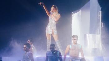 Infinite Icon: A Visual Memoir movie: Hazy image of Paris Hilton singing in a big stage production with shirtless male dancers