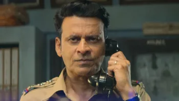 Inspector Zende movie: Indian man with short black hair in police uniform brings black phone receiver to his ear