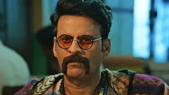 Inspector Zende movie: Indian man with short black hair wears 1960s "hippie" disguise, mustache, circle glasses, tie-dye shirt