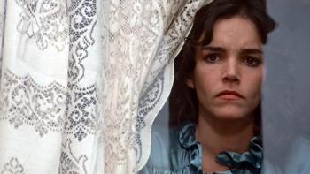 Invasion of the Body Snatchers Movie: Elizabeth (Brooke Adams) peers out a window with a concerned look on her face