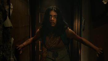It Lives Inside Movie: Samidha (Megan Suri) enters a hallway, looking anxious and scared, bracing herself on the walls with her hands