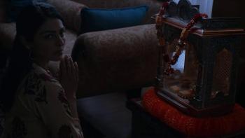 It Lives Inside Movie:  Samidha's mother, Poorna (Neeru Bajwa), prays in front of a home altar; she looks to her right as someone enters the room