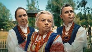 It Takes a Village: Three women in traditional garb look stern