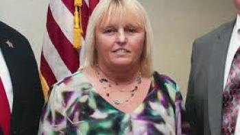 Jailbreak: Vicky White stands beside a flag
