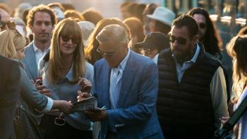 Jay Kelly: Movie star Jay Kelly (George Clooney) signs autographs in a huge crowd, flanked by his publicist (Laura Dern) and manager (Adam Sandler)
