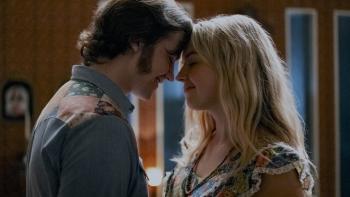 Jesus Revolution Movie: Joel Courtney as Pastor Greg Laurie and Anna Grace Barlow as Cathe smile as they embrace with their foreheads touching