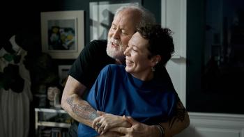 Jimpa: John Lithgow and Olivia Colman smile as he hugs her from behind