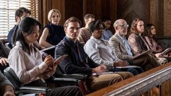 Juror #2 Movie: Justin Kemp (Nicholas Hoult) sits in the jury box, looking to his right while others look ahead