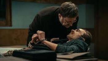 Justice: One man leans over another one who is handcuffed