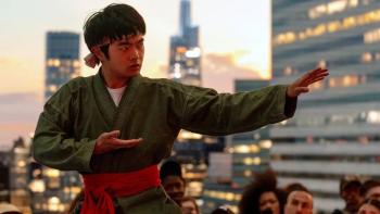 Karate Kid: Legends movie: Li Fong (Ben Wang), wearing a martial arts uniform, poses against a city skyline