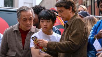Karate Kid: Legends movie: Shifu Han (Jackie Chan), Li Fong (Ben Wang), and Daniel LaRusso (Ralph Macchio) look at a pamphlet