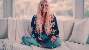 Karol G: Interview subject on couch.