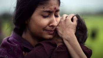 K.G.F. -- Chapter 2: An Indian woman holds her child tightly to her chest