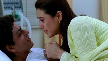 Kal Ho Naa Ho: Aman lies on a hospital bed and Naina sits beside him, leaning in; both characters are emotional