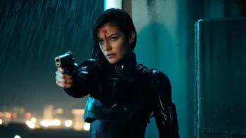 Kill Code: Woman in armor aiming a gun in the rain with a serious expression