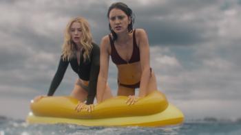 Killer Whale Movie: Maddie and Trish are perched atop a yellow float, looking at something in the water