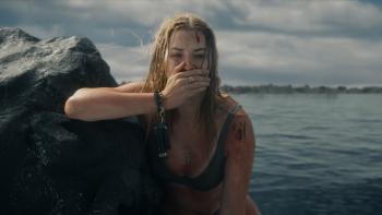 Killer Whale Movie: Maddie is perched on a rock, bloody cuts on her face and shoulder, her hand over her mouth in shock