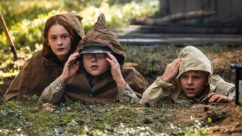 Mr. Car and the Knights Templar movie: Three kids wearing ponchos hunch on the ground as they secretly watch something ahead of them.