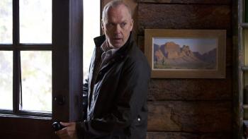 Knox Goes Away Movie: Knox (Michael Keaton) slips inside a doorway, looking as if he's breaking in and trying to be cautious