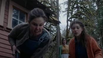 Lazareth movie: Ashley Judd angrily holds a gun outswide of Lazareth with Katie Douglas looking frightened 