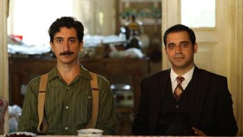 Lefter: The Story of Ordinarius movie: Turkish men sit at a desk facing forward, left wears suspenders and has mustache, right wears dark suit