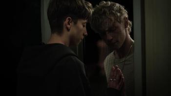 Leviticus Movie: Naim and Ryan lovingly touch each other's hands through a screen door