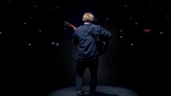 Lewis Capaldi: How I'm Feeling Now: Lewis Capaldi is seen from behind, playing a guitar toward a darkened stadium