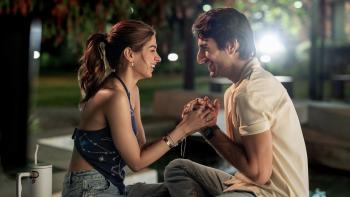 Nadaaniyan: A young man and woman sit close together at night, holding hands and laughing