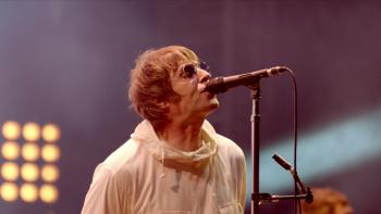 Liam Gallagher: Knebworth 22 -- White middle-aged rock singer in white coat performs on stage