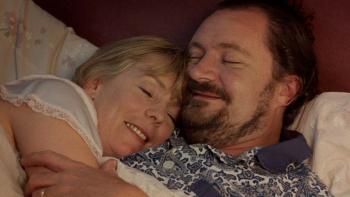 Life Is Sweet: A husband and wife both smile as they cuddle up in bed