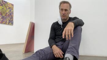 Life Upside Down Movie: Bob Odenkirk sits, with a COVID mask hanging off of one ear, looking dejected