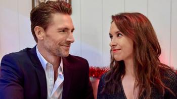 She's Making a List movie: A young White man and woman smile at each other as they sit side by side