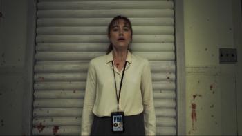 Longlegs Movie: Wearing her FBI badge, Lee Harker (Maika Monroe) stands, horrified, against a wall spattered with blood