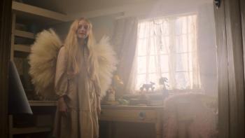 Lord of Misrule: A young White girl stands in bedroom wearing wings with light shining through the window.