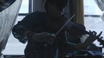 Love and Fury: Native American woman plays violin in dark apartment
